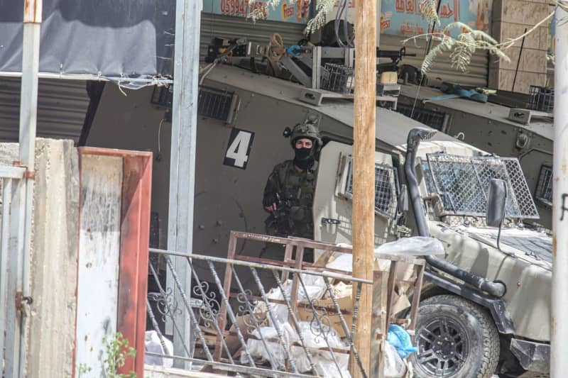 Israeli soldiers stand guard and surround a house where armed Palestinians are staying during a raid. The operation lasted more than 24 hours in which the Israeli forces killed more than five Palestinians and injured dozens during the raid in the Palestinian refugee camp of Nour Shams. Nasser Ishtayeh/SOPA Images via ZUMA Press Wire/dpa