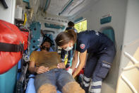 A nurse treats an exhausted Turkish volunteer as they fight wildfires in Turgut village, near tourist resort of Marmaris, Mugla, Turkey, Wednesday, Aug. 4, 2021. As Turkish fire crews pressed ahead Tuesday with their weeklong battle against blazes tearing through forests and villages on the country's southern coast, President Recep Tayyip Erdogan's government faced increased criticism over its apparent poor response and inadequate preparedness for large-scale wildfires.(AP Photo/Emre Tazegul)