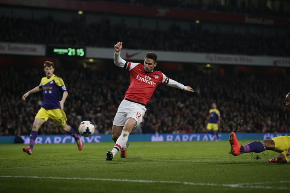 Arsenal's Olivier Giroud, center, scores his side's second goal during the English Premier League soccer match between Arsenal and Swansea City at the Emirates Stadium in London, Tuesday, March 25, 2014. (AP Photo/Matt Dunham)