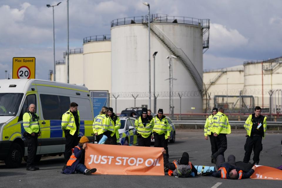 Police officers look at activists from Just Stop Oil taking part in a blockade at the Kingsbury Oil Terminal, Warwickshire (PA) (PA Wire)