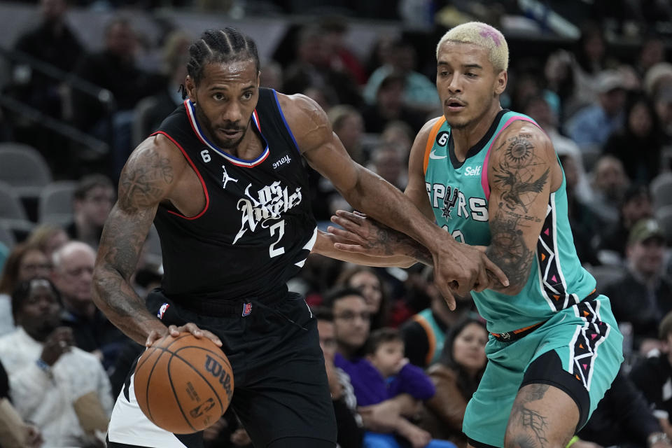 Los Angeles Clippers forward Kawhi Leonard (2) drives around San Antonio Spurs forward Jeremy Sochan (10) during the second half of an NBA basketball game in San Antonio, Friday, Jan. 20, 2023. (AP Photo/Eric Gay)