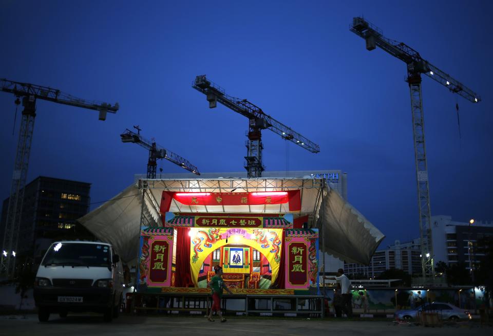 A performer walks past a traditional Chinese opera stage built next to the construction site in a public housing neighbourhood during the Hungry Ghost festival in Singapore August 7, 2014. The Hungry Ghost Festival, from July 27 to August 24 , is celebrated with traditional Chinese operas, puppet shows and concerts held by believers to appease roaming spirits. REUTERS/Edgar Su (SINGAPORE - Tags: SOCIETY RELIGION TPX IMAGES OF THE DAY)