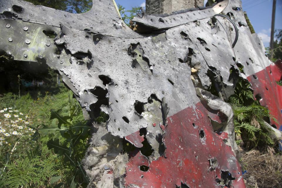 FILE - In this Wednesday, July 23, 2014 file photo, a piece of the crashed Malaysia Airlines Flight 17 lies in the village of Petropavlivka, Donetsk region, eastern Ukraine. The Dutch government is taking to Russia to the European Court of Human Rights for its alleged role in the shooting down of Malaysia Airlines Flight 17 over eastern Ukraine six years ago, the foreign minister announced Friday July 10, 2020. (AP Photo/Dmitry Lovetsky, File)