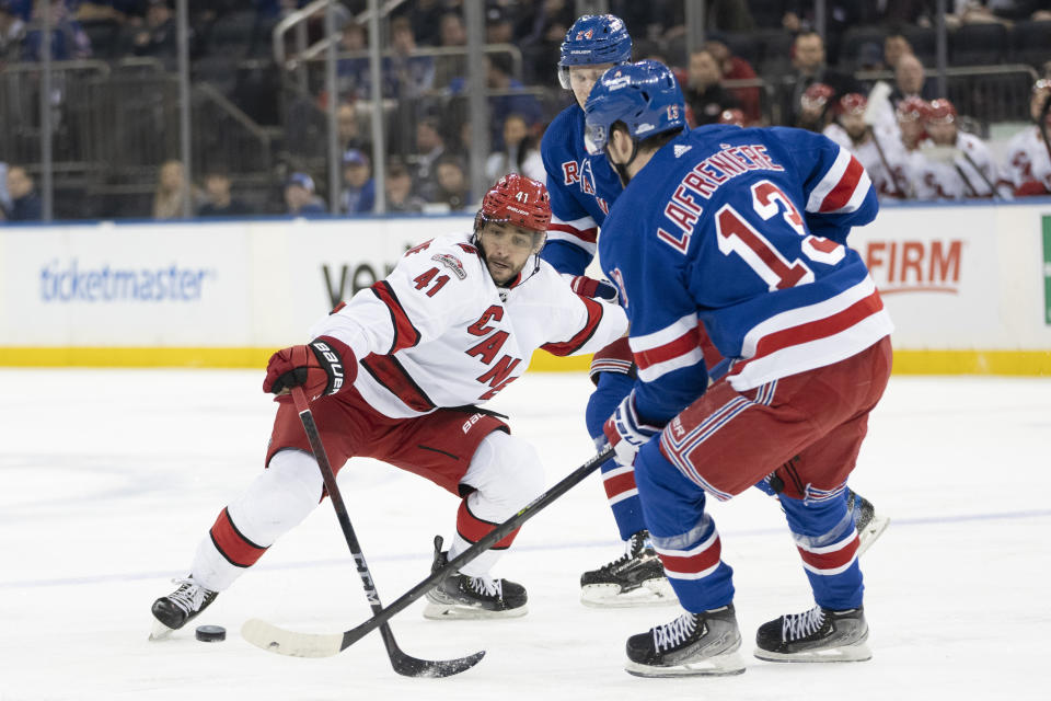 Carolina Hurricanes defenseman Shayne Gostisbehere (41) is defended by New York Rangers left wing Alexis Lafrenière (13) and right wing Kaapo Kakko during the first period of an NHL hockey game Tuesday, March 21, 2023, at Madison Square Garden in New York. (AP Photo/Mary Altaffer)
