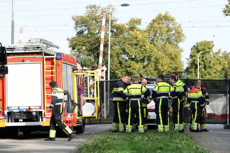 Rescue personnel work at the scene where a train struck a "cargo bicycle", popular with Dutch parents for transporting their children, at the city of Oss, Netherlands, September 20, 2018. REUTERS/Piroschka van de Wouw