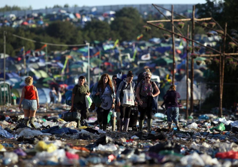 Festival-goers walk through rubbish as they begin to leave Glastonbury in 2011. (Getty Images)