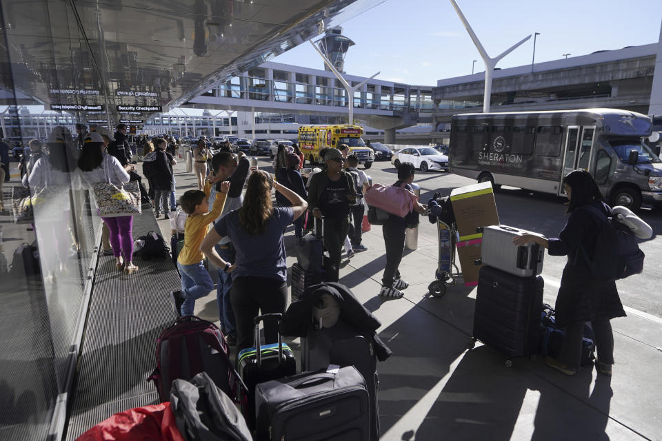 Holiday travelers wait for ground transportation during the week of Thanksgiving, Wednesday, Nov. 22, 2023, at Los Angeles International Airport in Los Angeles. The late crush of holiday travelers is picking up steam, with about 2.7 million people expected to board flights on Wednesday and millions more planning to drive or take the train to Thanksgiving celebrations. (AP Photo/Damian Dovarganes)