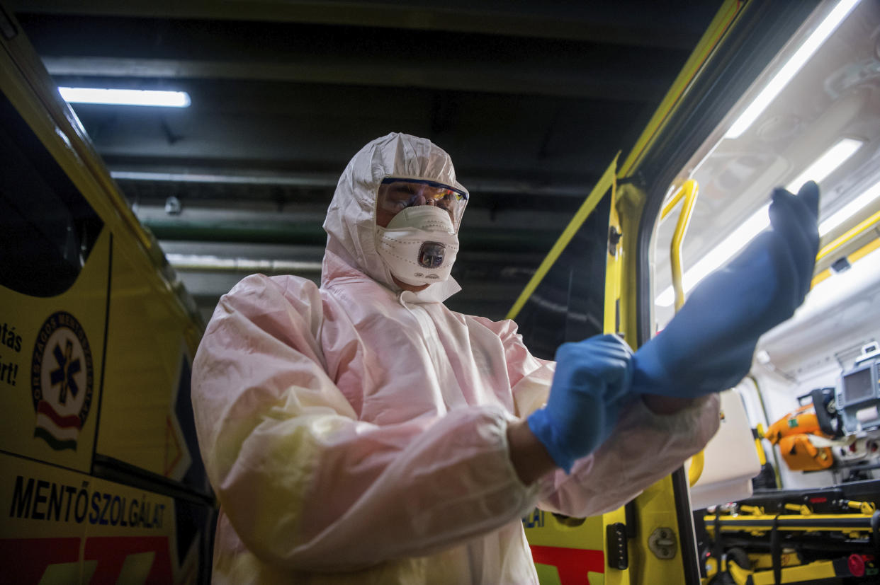 A paramedic on call puts on protective gear as a precaution against the spread of the novel coronavirus in the garage of the Mohacs street station of the National Ambulance Service Budapest, Hungary, Tuesday, March 10, 2020. Any patients suspected of having contracted the Covid-19 infection will be taken to hospital by the order of their general practitioner. Today another three cases have emerged in Hungary, bringing the number of confirmed cases of Covid-19 in the country to 12. A total of 67 people are in quarantine, while samples have been taken from 362 people suspected of carrying the virus. (Zoltan Balogh/MTI via AP)