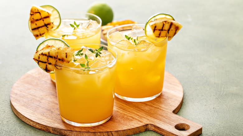 smoked pineapple margaritas on wooden cutting board