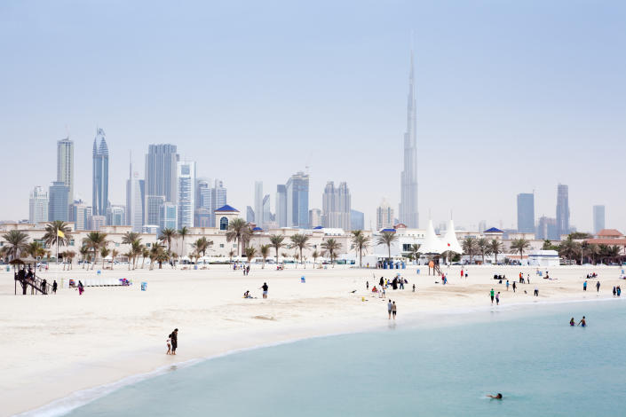 A landscape image of Dubai with a beach in the foreground. 