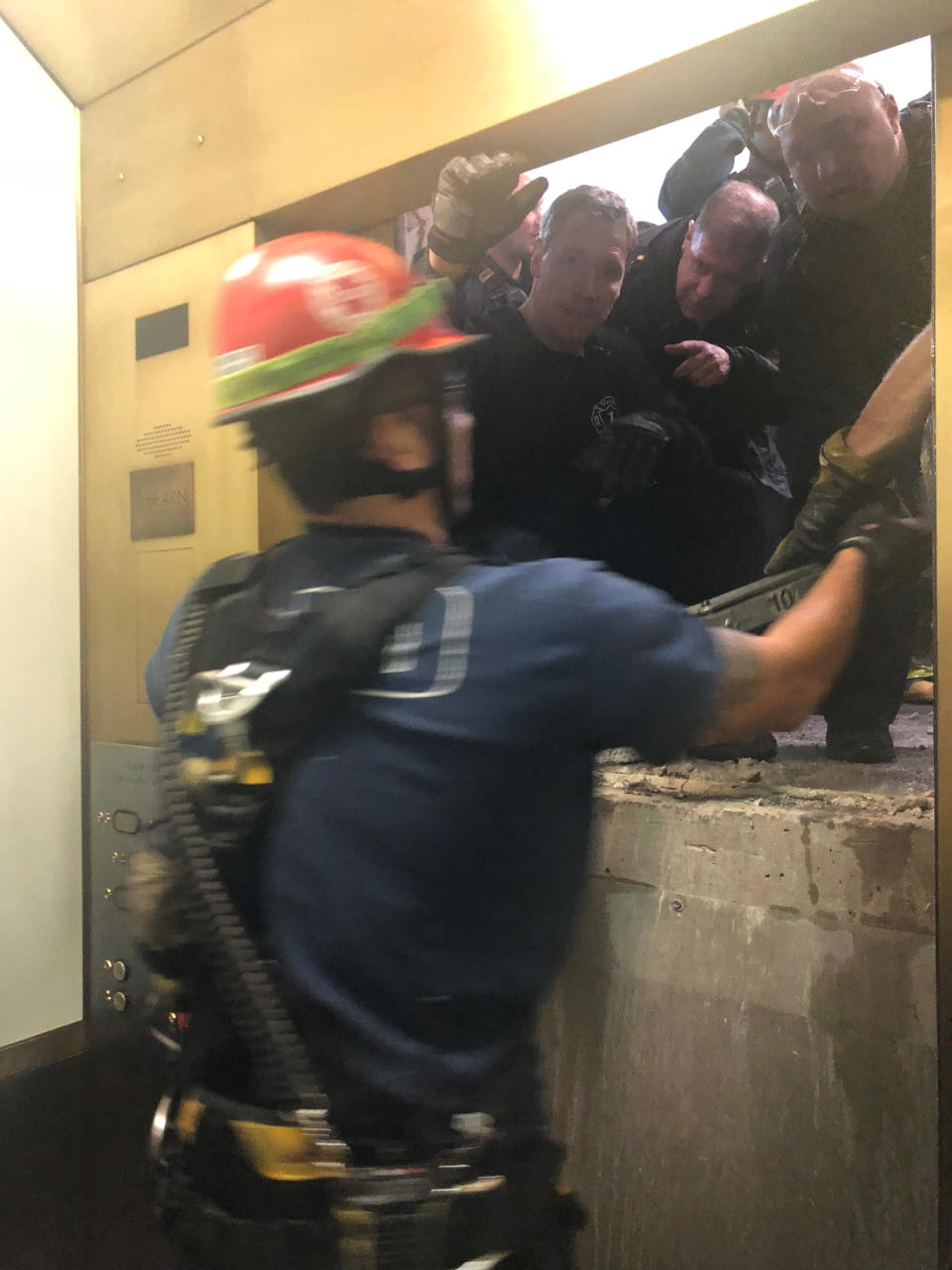 Los rescatistas rompieron una pared y abrieron la puerta para sacar a las personas atrapadas dentro del ascensor. Katy Martinez/via REUTERS