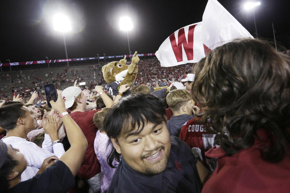 Washington State mascot Butch T. Cougar, center, is hoisted as fans and players celebrate on the field after team's 31-22 win over Wisconsin in an NCAA college football game Saturday, Sept. 9, 2023, in Pullman, Wash. (AP Photo/Young Kwak)