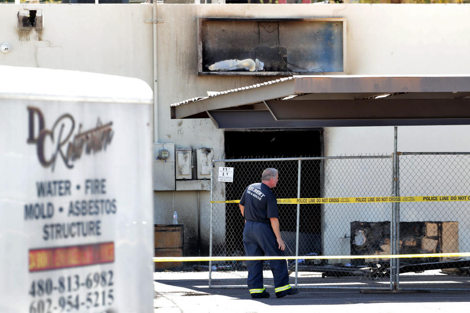 Fire investigators stand outside the Arizona Democratic Party headquarters Friday, July 24, 2020, in Phoenix. Fire investigators are looking into the cause of an early morning blaze that destroyed part of the Arizona and Maricopa County Democratic Party headquarters Friday. (AP Photo/Matt York)