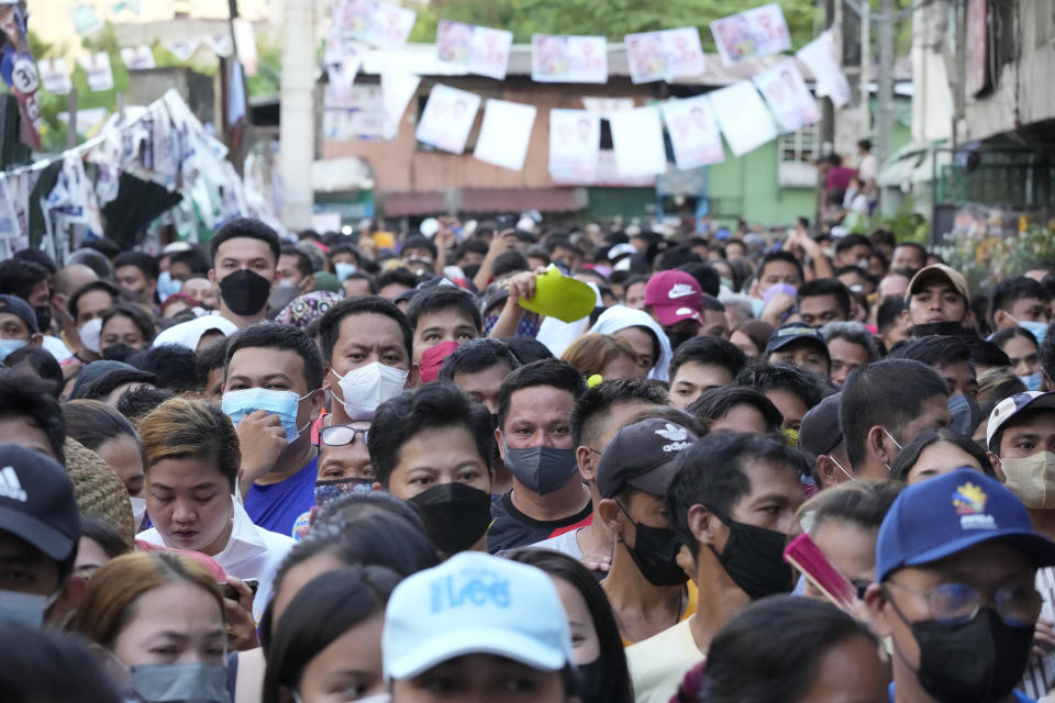 People wait in line to vote at a school used as a polling station in Tondo district of Manila, Philippines on Monday, May 9, 2022. About 67 million registered Filipino voters will pick a new president on Monday, with Ferdinand Marcos, Jr, son and namesake of the ousted dictator leading pre-election surveys, and incumbent Vice President Leni Robredo, who leads the opposition, as his closest challenger. (AP Photo/Aaron Favila)