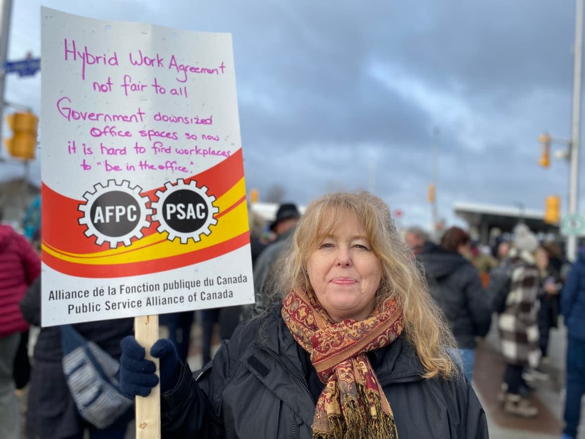 Christine Griffin holds a sign at a Public Service Alliance of Canada picket at the Tunney's Pasture government complex in Ottawa on April 19, the first day of the walkout. (Joseph Tunney/CBC - image credit)