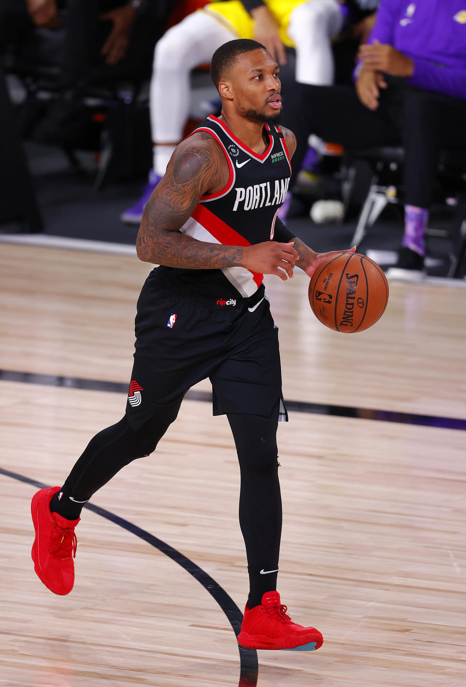 Damian Lillard of the Portland Trail Blazers dribbles the ball during the second quarter against the Los Angeles Lakers in Game 1 of an NBA basketball first-round playoff series, Tuesday, Aug. 18, 2020, in Lake Buena Vista, Fla. (Mike Ehrmann/Pool Photo via AP)