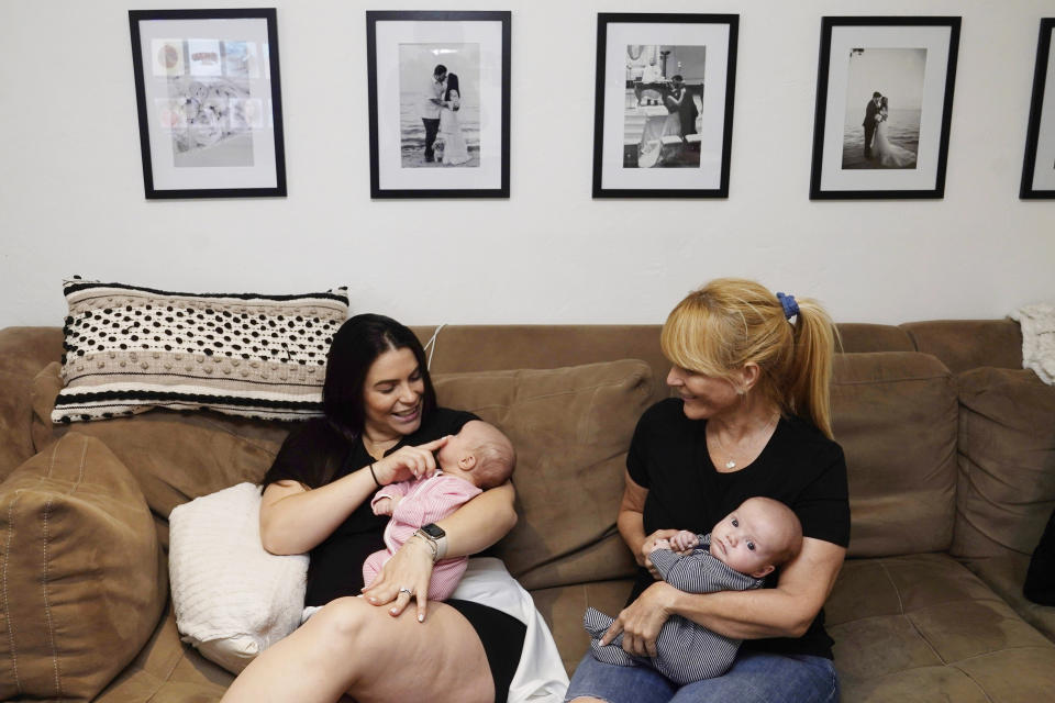 Lissette Fernandez holds her daughter Lexi as her mother Mayda Hurtado holds her son Luca, Tuesday, May 24, 2022, in Coral Gables, Fla. (AP Photo/Marta Lavandier)