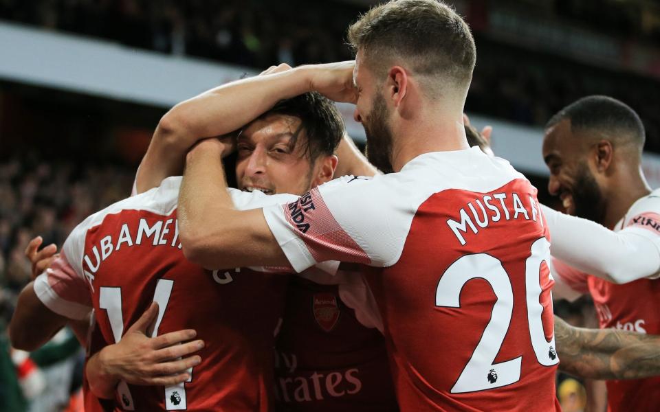 Mesut Ozil is mobbed by his Arsenal team-mates - Getty Images Europe