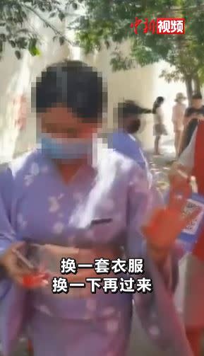 女子被擋後沒有抗議，比了OK手勢就離開。（圖／翻攝自中新視頻）