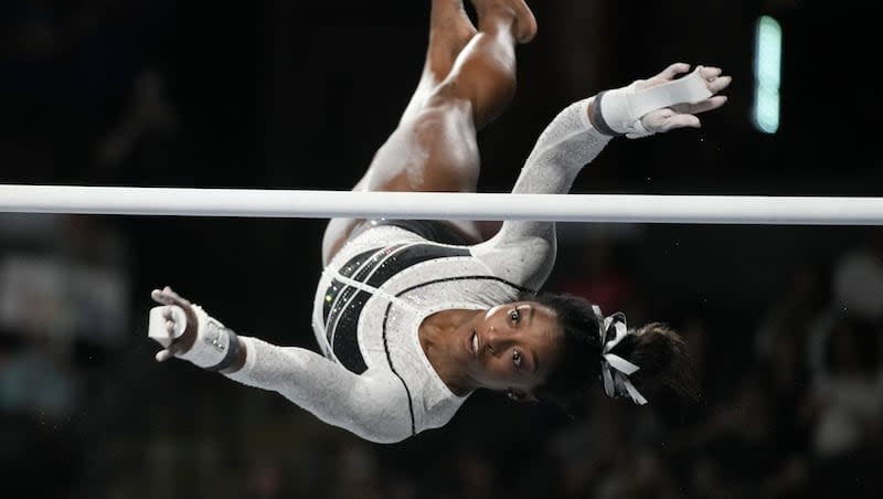 Simone Biles performs on the uneven bars at the U.S. Classic gymnastics competition on Aug. 5, 2023, in Hoffman Estates, Ill. The IOC will use artificial intelligence to monitor social media to prevent the online abuse of athletes competing in the Paris Olympics.