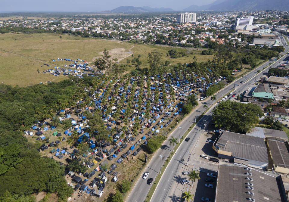 FILE - In this May 26, 2021 file photo, tents and shacks cover land designated for a Petrobras refinery, called the "First of May Refugee Camp," which refers to the date the squatters camp sprung up amid the new coronavirus pandemic, in Itaguai, Rio de Janeiro state, Brazil. In the first quarter of 2021, Brazil saw its highest unemployment and economic inequality in at least nine years, with the cost of living surging and tent cities and shantytowns emerging. (AP Photo/Mario Lobao, File)