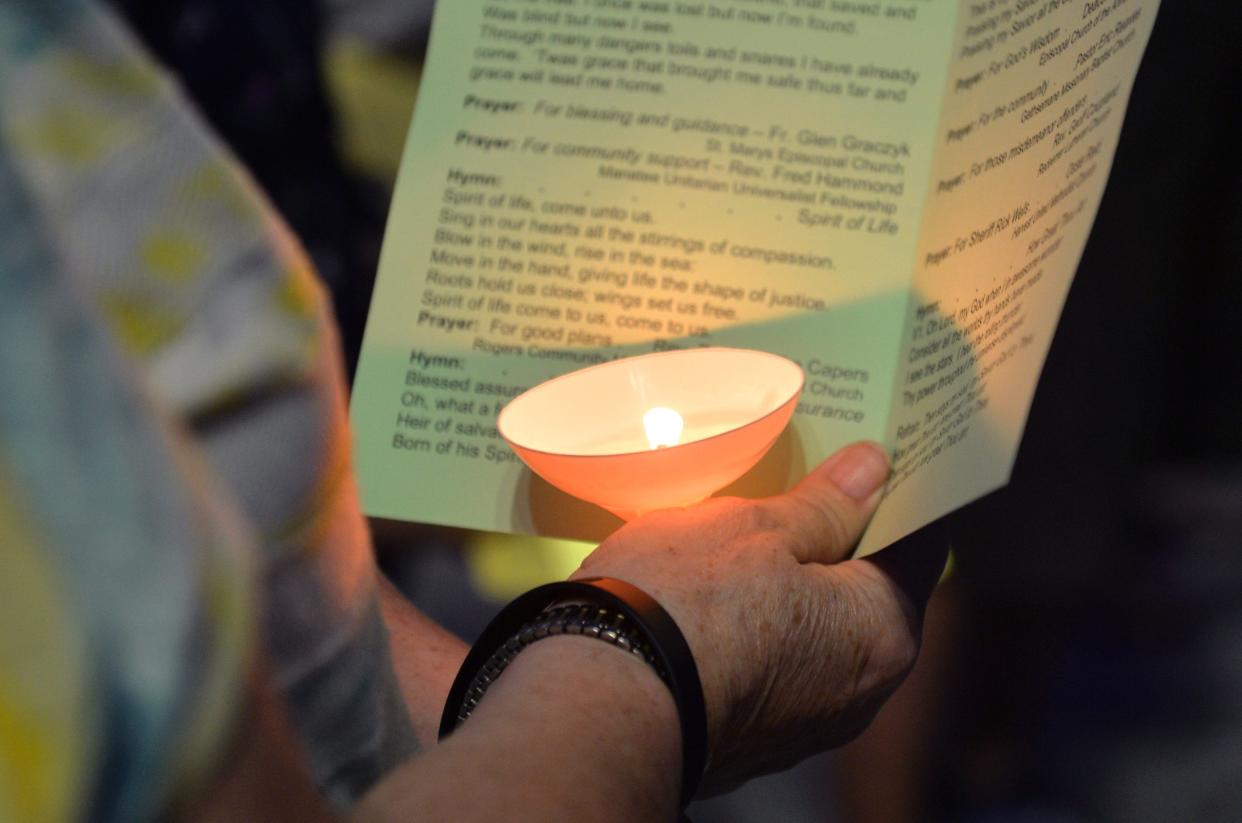 A S.T.R.E.A.M. (Stronger Together Reaching Equality Across Manatee) team member holds a candle as she sings from the program Thursday evening, March 9, 2023, during a vigil to pray for a meeting with Manatee County Sheriff Rick Wells.