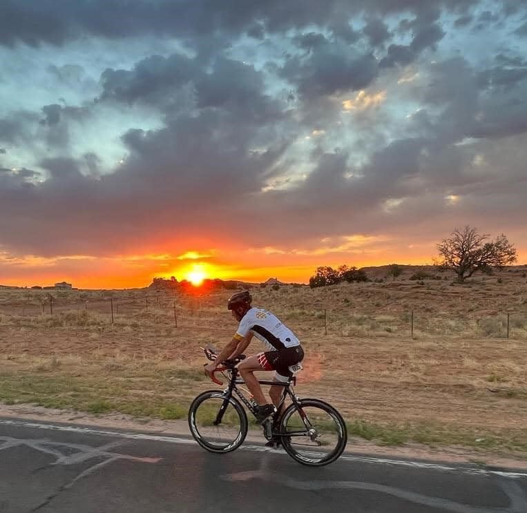 Les Crooks of Mishawaka bikes by Monument Valley near the Arizona-Utah border as the sun rises on the Race Across America in June 2022.