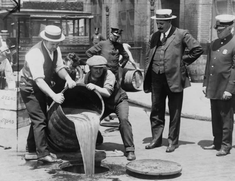 New York City Deputy Police Commissioner John A. Leach (R) watches agents pour liquor into sewer following a raid during the height of prohibition. On January 16, 1919, the United States went legally "dry" when the 36th state ratified the 18th Amendment. File Photo courtesy Library of Congress