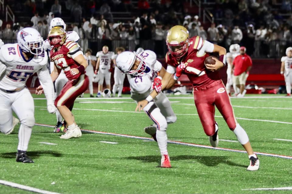 Portsmouth quarterback Aidan Thomas tries to break away from Memorial's Chase Burris in the first half of Friday's Division I football game.