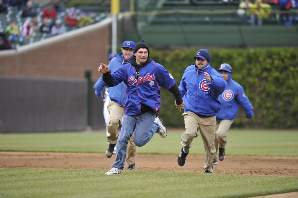 Chicago Cubs security chase after a fan who ran on the field during the game against the Cincinnati Reds at Wrigley Field on April 20, 2012 in Chicago, Illinois. The Reds defeated the Cubs 9-4. (Photo by Brian D. Kersey/Getty Images)