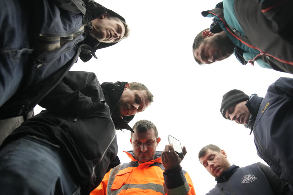 Farmers listen to French Prime Minister Gabriel Attal announcing new measures for farmers on a blocked highway, Thursday, Feb.1, 2024 in Chilly-Mazarin, south of Paris. Protests have been held across the EU for most of the week and hundreds of angry farmers driving heavy-duty tractors arrived at European Union headquarters, bent on getting their complaints about excessive costs, rules and bureaucracy heard and fixed by EU leaders at a summit Thursday in Brussels, Belgium. (AP Photo/Christophe Ena)