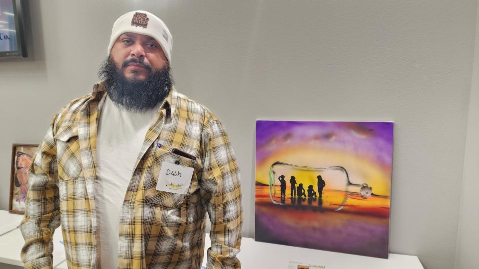 Juan "Dash" Jimenez stands with his artwork Friday night at the HeART of CASA fundraiser in downtown Amarillo.