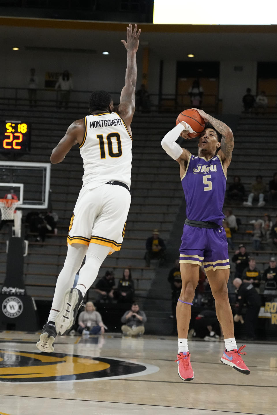 James Madison guard Terrence Edwards Jr. (5) attempts a three-point shot over the defense of Southern Mississippi guard Cobie Montgomery (10) during the first half of an NCAA college basketball game, Saturday, Jan. 6, 2024, in Hattiesburg, Miss. (AP Photo/Rogelio V. Solis)