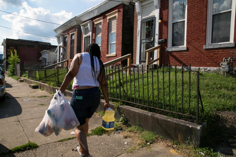 Chaunda Lee, a single mother of eight who has five children living with her, carries groceries home to make dinner for her kids, in Louisville, Kentucky, U.S. August 19, 2021. Lee was granted a reprieve from her eviction as the extended CDC moratorium was applied to her case, despite the landlord saying in court that she hadn't paid rent for six months after the two months rent free she offered her. REUTERS/Amira Karaoud