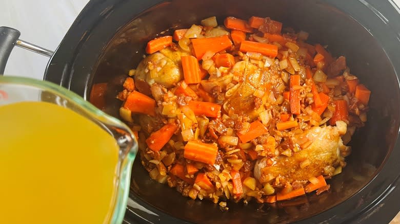 pouring chicken stock into crockpot