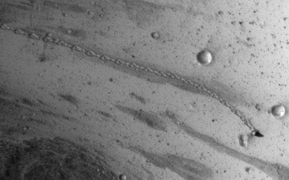 NASA's Mars Reconnaissance Orbiter spotted the trail from an oblong boulder (bottom right) that rolled down a slope on the Red Planet. The image was taken on July 3, 2014.