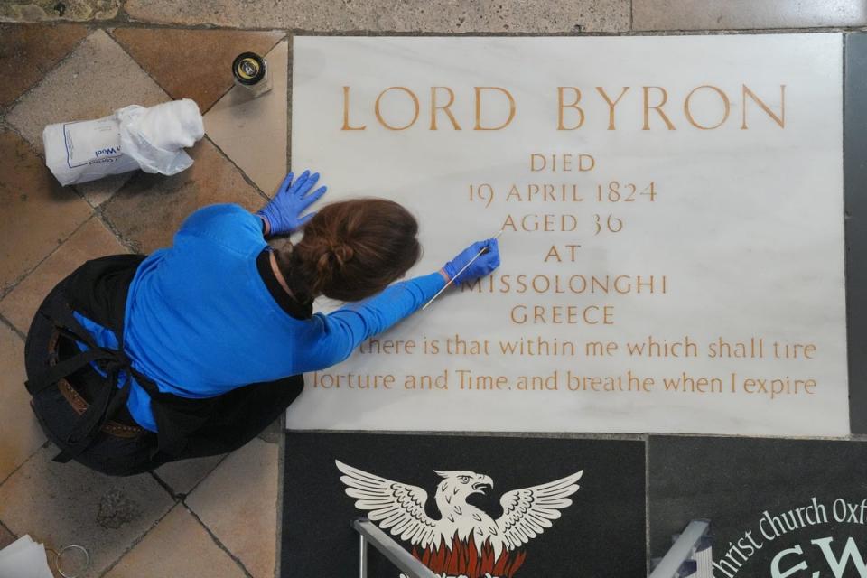 A conservator cleans Lord Byron's memorial stone in Poets' Corner at Westminster Abbey in London, ahead of the 200th anniversary of his death (Jonathan Brady/PA)