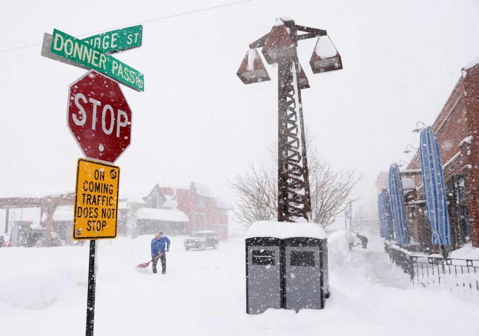 Nick Muzik shovels snow outside of the Bar of America as snow continues to fall in downtown Truckee on Sunday. Another local resident, Rudy Islas, said those who know are taking the storm in stride: “To be honest, if you’re a local, it’s not a big deal.”