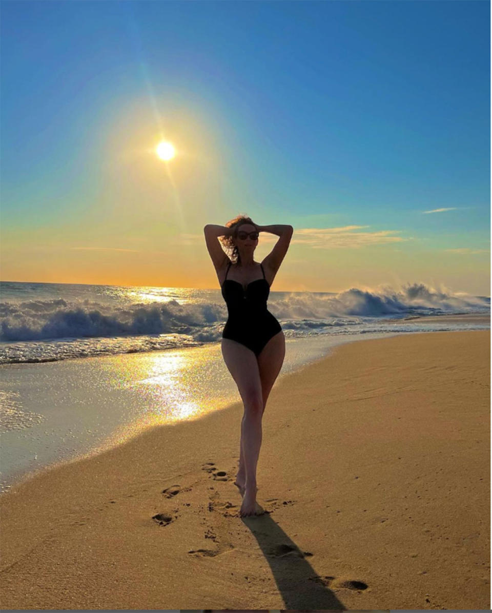 Ricki-Lee Coulter in a swimsuit in front of a Cabo sunset