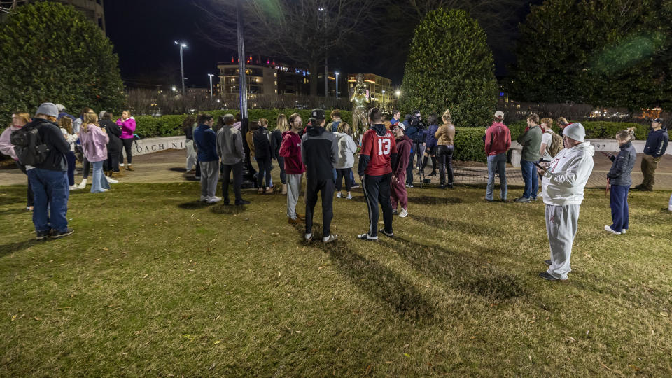 The statue of Alabama football coach Nick Saban, along the Walk of Champions at Bryant-Denny Stadium, is the scene of gift drop-offs and lingering fans Wednesday, Jan. 10, 2024, in Tuscaloosa, Ala. Saban, who won seven national championships — more than any other major college football coach — and turned Alabama back into a national powerhouse with six of those titles in just 17 seasons, is retiring, according to multiple outlets. (AP Photo/Vasha Hunt)