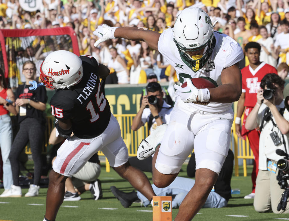 Baylor Bears tight end Drake Dabney, right, scores a touchdown past Houston defensive back Malik Fleming (15) during the second half of an NCAA college football game, Saturday, Nov. 4, 2023, in Waco, Texas. (Jerry Larson/Waco Tribune-Herald via AP)