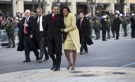 U.S. President Barack Obama and first lady Michelle Obama walk down Pennsylvania Avenue enroute to the White House during the inaugural parade in Washington January 20, 2009. REUTERS/Doug Mills/Pool/File Photo