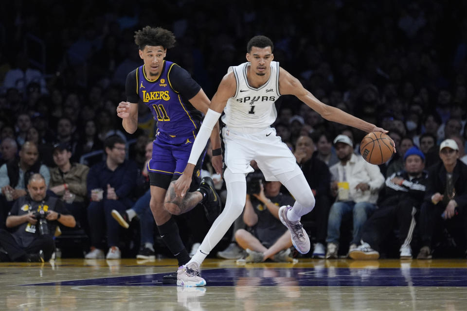 San Antonio Spurs center Victor Wembanyama (1) dribbles past Los Angeles Lakers center Jaxson Hayes (11) during the first half of an NBA basketball game Friday, Feb. 23, 2024, in Los Angeles. (AP Photo/Marcio Jose Sanchez)