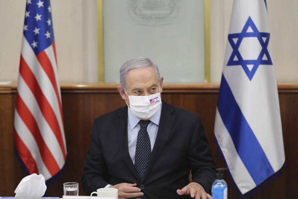 Israeli Prime Minister Benjamin Netanyahu attends a press briefing with US special envoy for Iran, Brian Hook, while wearing a face mask to help prevent the spread of the coronavirus, at the Prime Minister's office in Jerusalem, Tuesday June 30, 2020. (Abir Sultan/Pool via AP)