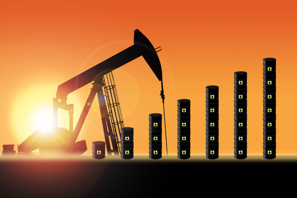 Rows of oil barrel drums increasing in bar chart format with pump jack silhouette against a sunset sky with deliberate lens flare and copy space. Concept of increasing oil production output or rising oil prices.