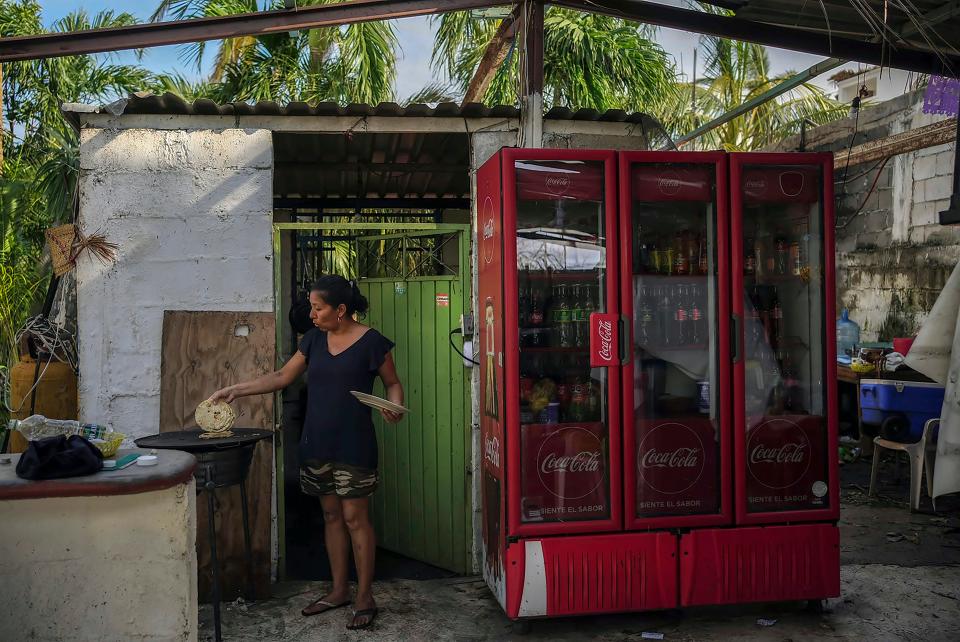 Natividad Reynoso cooks tortillas for her family in the aftermath of Hurricane Otis which ripped off part of her home's roof in Acapulco, Mexico, Friday, Oct. 27, 2023. Reynoso's business selling plants to hotels was wiped out by the Category 5 storm.
