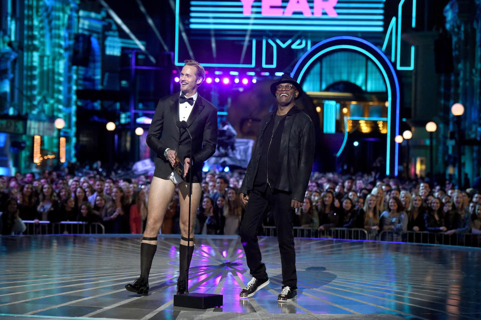 Alexander, in his no-pants look, presents an award next to Samuel L. Jackson