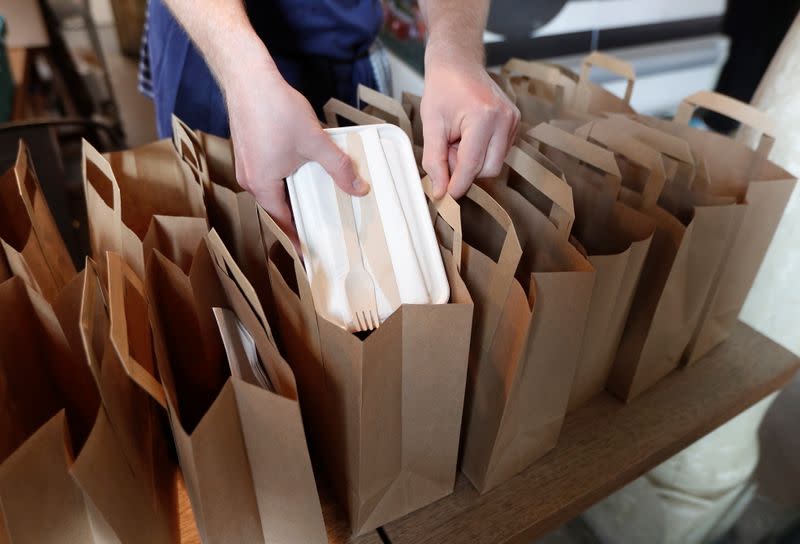 A chef from the St Giles Trust Brewbird cafe, prepares hot food packages for people in need of free school meals, in London