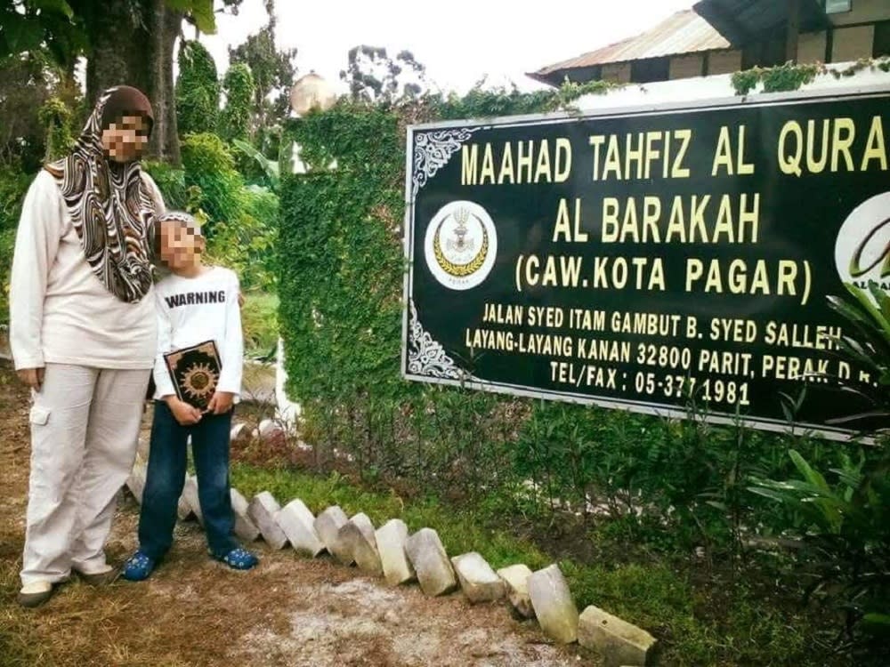 An undated photo of the victim and his mother in front of Maahad Tahfiz al Barakah — the tahfiz school in Manjoi formerly owned by celebrity preacher Datuk Kazim Elias.