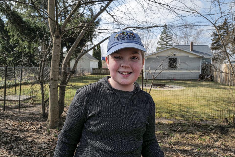 Sam Bliss, 11, smiles as he finishes cleaning up dog waste at one of his repeat clients in Charlotte Saturday, March 2, 2024.